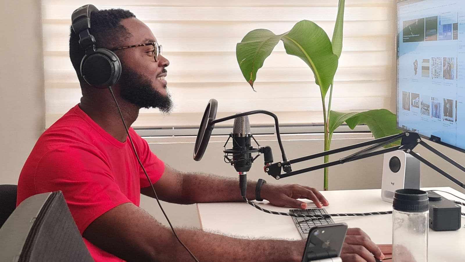 A creator recording a podcast at a home desk
