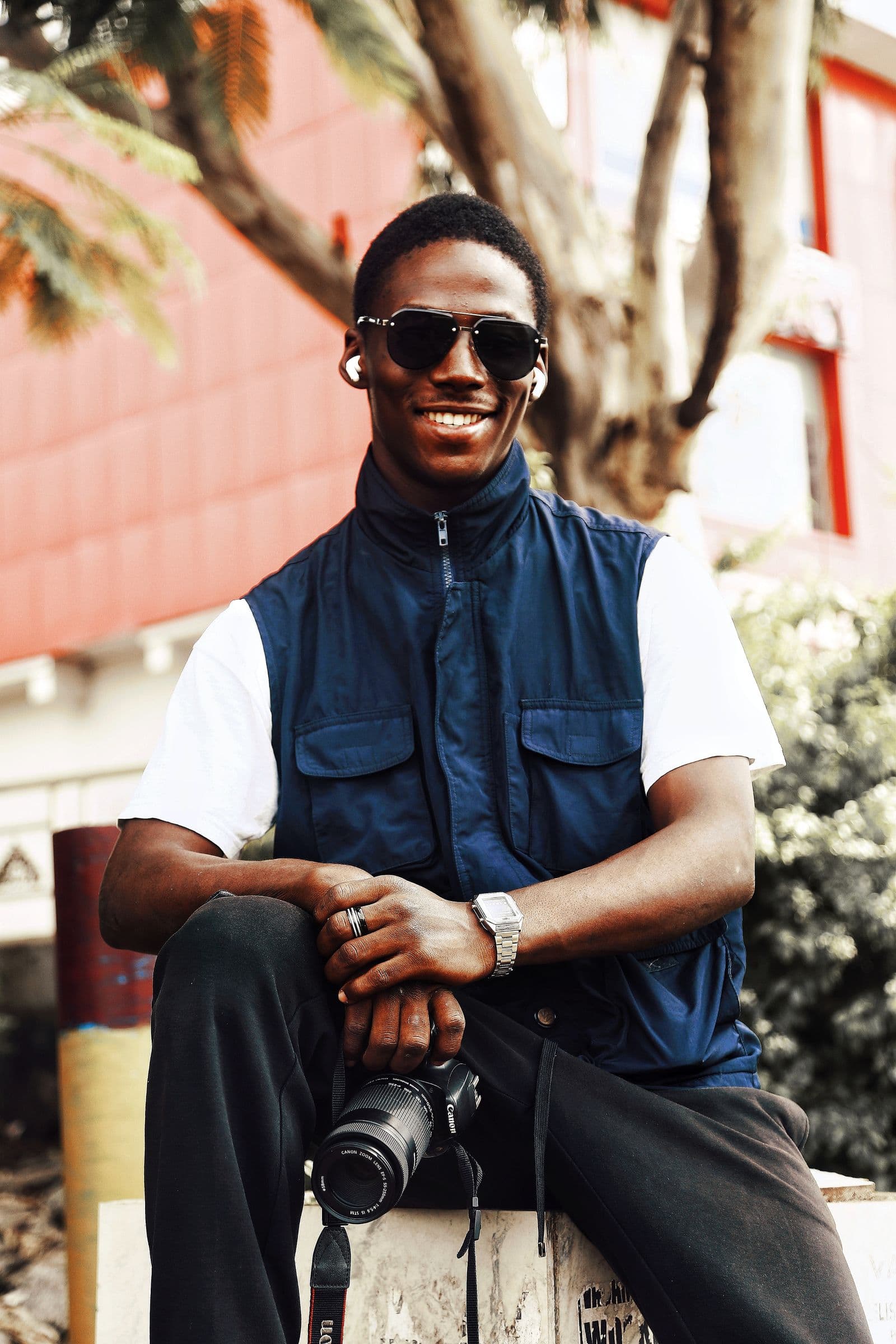 A photographer smiling outdoors with his camera